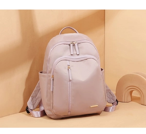 Detalle de una mochila de tela Oxford lavanda con cremalleras y un bolsillo frontal
