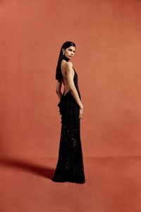 Detail of elegant black backless lace maxi dress with halter neck and tiered ruffle design