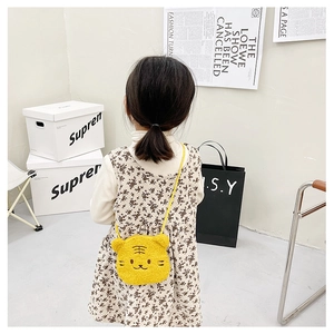 Detail of yellow plush cartoon tiger crossbody bag shown on child model back