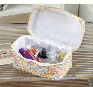 Detailed view of spacious floral quilted cotton toiletry bag with zipper closure on shelf