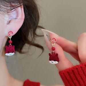 Detailed view of red flocked animal earrings with Fu character studs for festive look