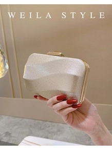Detail of champagne gold evening clutch featuring a rippled texture and metal frame