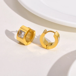 Detail of gold-plated thick hoop earrings with a square-cut white zircon stone setting