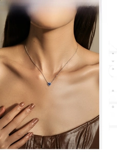 Gros plan d'un collier en opale bleue en forme de cœur sur une chaîne en argent porté