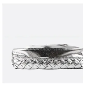 Detail of metallic silver tote bag featuring high-quality woven leather base texture