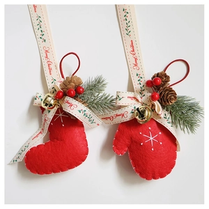 Detailed view of red felt Christmas stocking and glove ornaments with gold bells