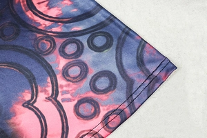 Detailed close-up of abstract print dress fabric showing high-quality double-needle stitching