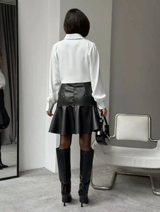Détail de la jupe noire en simili cuir à taille haute avec zip arrière et volants