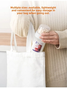 Detail showing the portable dual-layer yogurt container being placed into a canvas bag