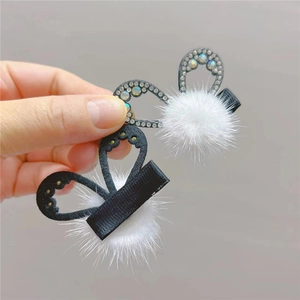 Detail of plush faux mink bow hair clips with sparkling rhinestones for young girls