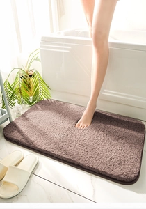 Close-up of brown plush bath mat showing thick water-absorbent texture and soft fibers