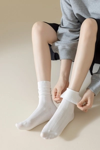 Détail de chaussettes mi-mollet en coton côtelé blanc avec texture douce et poignet