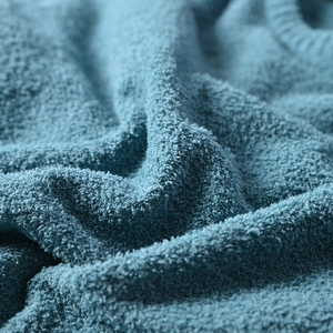 Close-up of the soft blue knitted fabric texture on the men's crewneck sweater