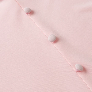 Close-up of pink textured knit dress featuring three matching fabric-covered buttons