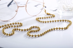 Detail of gold beaded stainless steel eyewear chain with lobster clasp and silicone loops