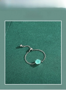 Macro detail of adjustable S925 silver chain ring with round cyan paraiba tourmaline stone