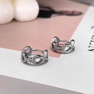 Macro shot of silver infinity loop earrings with a polished geometric cutout design