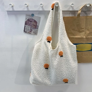 Detail of ivory plush fleece tote bag with orange 3D embroidery and wide shoulder strap