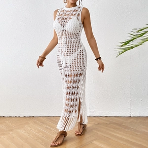 Détail de la robe de plage en crochet blanc avec motif ajouré et finitions à franges
