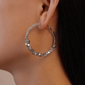 Side view of model wearing large silver geometric hoop earrings with sparkling rhinestones