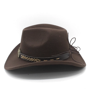 Detail of dark brown felt cowboy hat with decorative black leather band and vintage badge