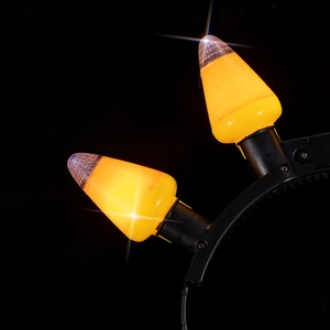 Macro view of glowing orange pumpkin bulbs and black frame on a festive headband