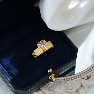 Detailed macro view of 18K gold plated ring with rectangle zircon in a blue velvet box