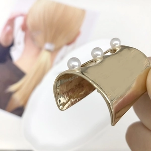 Elegant gold U-shaped metal hair pin with large pearls for a minimalist ponytail look