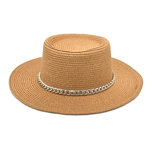 Detail of a brown woven boater hat with a decorative silver chain on a white background