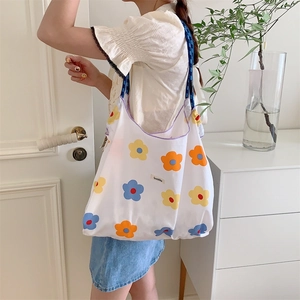 Detail of floral canvas tote bag with woven blue strap and large capacity floral print
