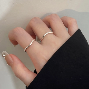 Close-up of minimalist S925 sterling silver wave rings worn on a hand with manicure
