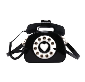 Detailed close-up of retro black telephone handbag showing dial and handset handle