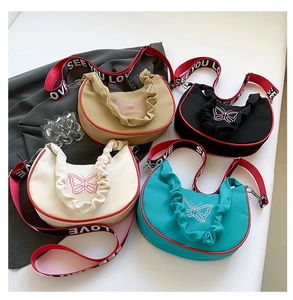 Détail de sacs à bandoulière en nylon avec broderie papillon rose et bord plissé