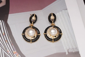 Détail de boucles d'oreilles vintage en émail avec perles et zircons sur un magazine