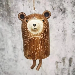 Close-up of a rustic brown resin bear wind chime hanging from a natural jute rope