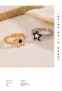 Dettaglio di anelli a stella regolabili placcati oro 18K con smalto a goccia bianco e nero