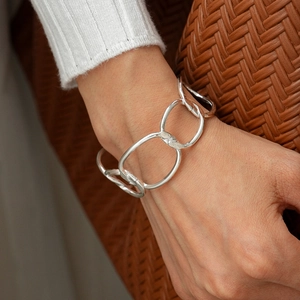 Macro shot of oversized polished silver links on a geometric open cuff bracelet for women