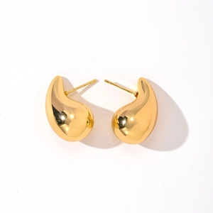 Detailed view of teardrop gold stud earrings featuring a polished high-shine finish