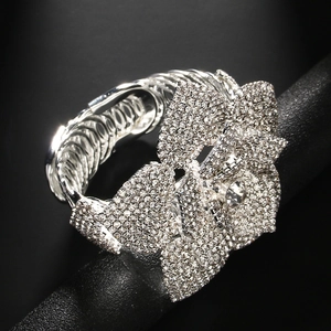 Bracciale rigido di lusso con fiore grande e cristalli su supporto nero