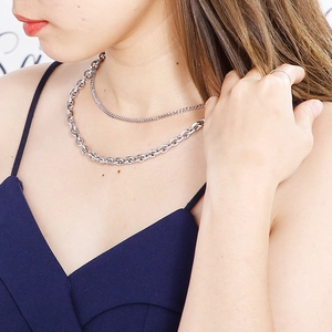 Close-up of double layered silver titanium steel chain necklace on male model's neck