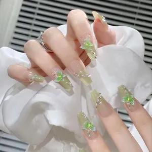 Detail of long coffin press-on nails with green gradient and 3D butterfly charms