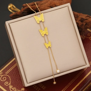 Detailed view of golden butterfly tassel necklace on luxury jewelry box with zircon accents