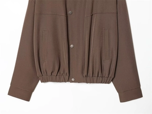 Détail de la veste aviateur marron avec boutons-pression en argent et ourlet élastique