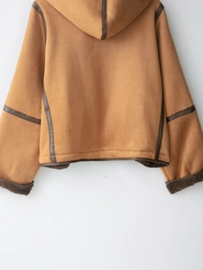Detail view of camel suede hood and dark brown leather trim on a thick winter coat