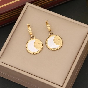 Detail of gold hoop earrings with white mother-of-pearl and sunray texture inlays