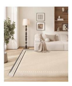 Close-up of chenille rectangular rug with geometric edges in a modern cream living room