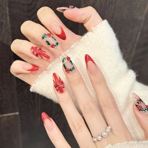 Christmas themed red glitter press-on nails with 3D bow and wreath almond design