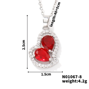 Dettaglio pendente a cuore con pietre rosse a goccia e dimensioni 2.5x1.5cm
