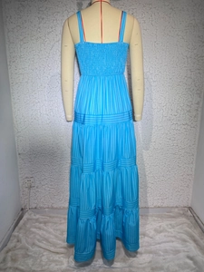 Detail of blue striped maxi dress featuring a smocked bodice and layered tiered skirt
