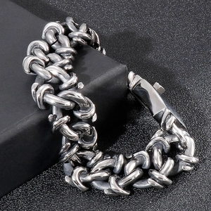 Detail of high-polished stainless steel heavy chain bracelet on a black geometric stand